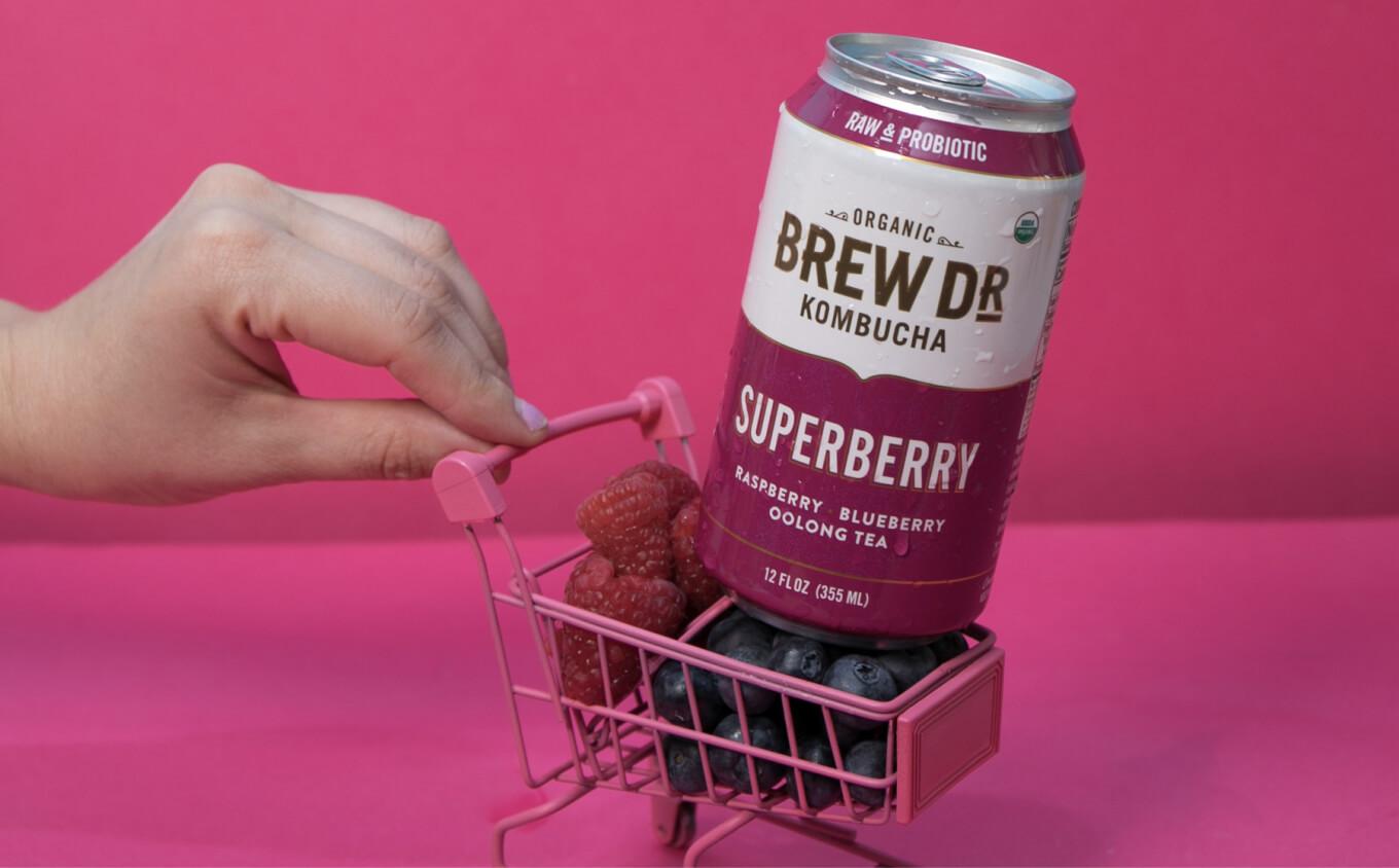 Can of Brew Dr Kombucha super berry flavour in a cart full of berries
